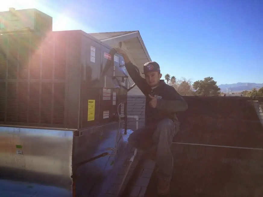 HVAC technician performing Boiler Repair on a rooftop unit in Arvada